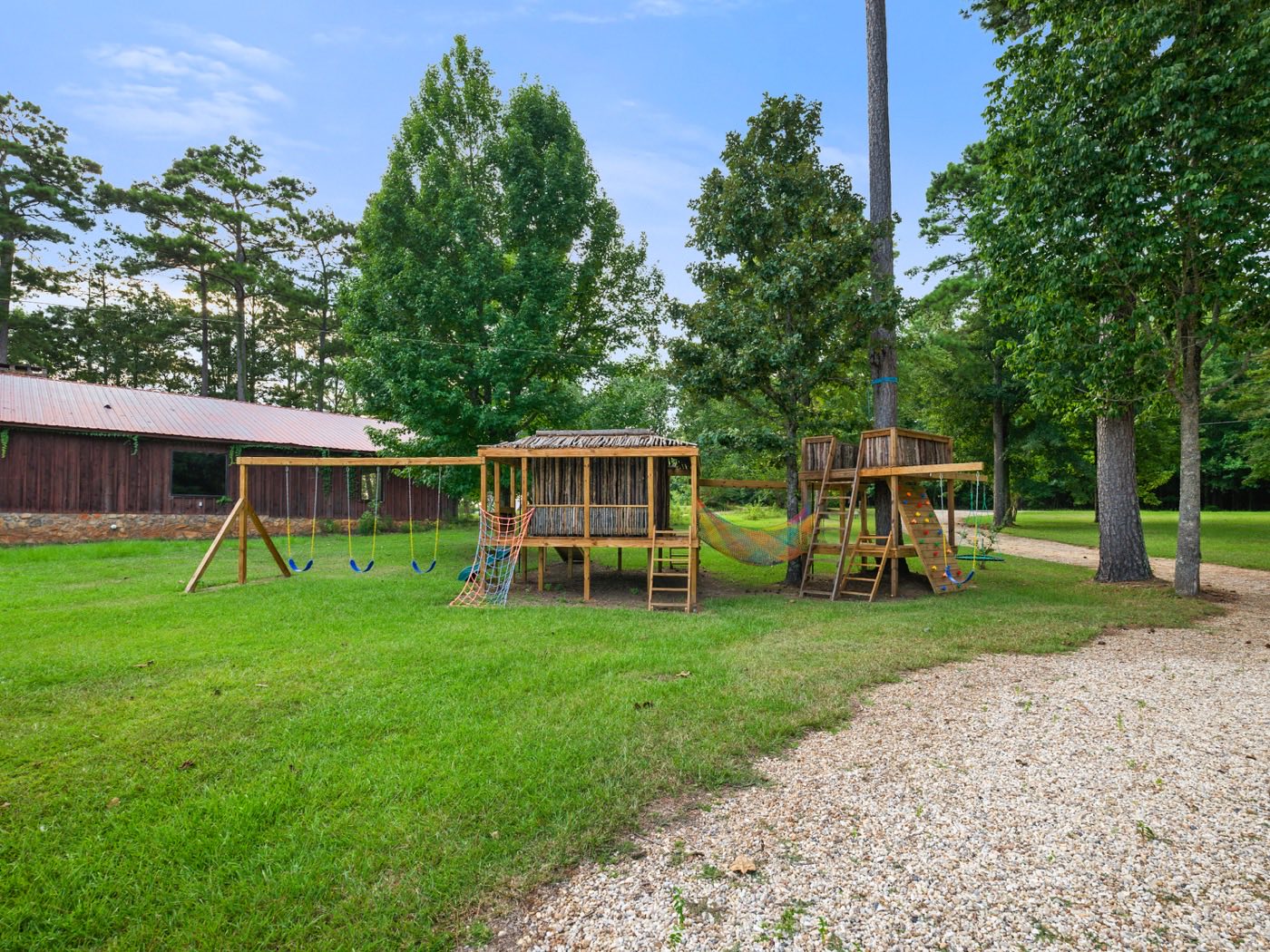 Large backyard play structure with swings and climbing wall