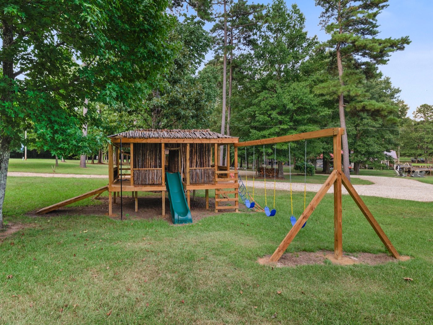 Wooden playset with clubhouse, slide, and swings