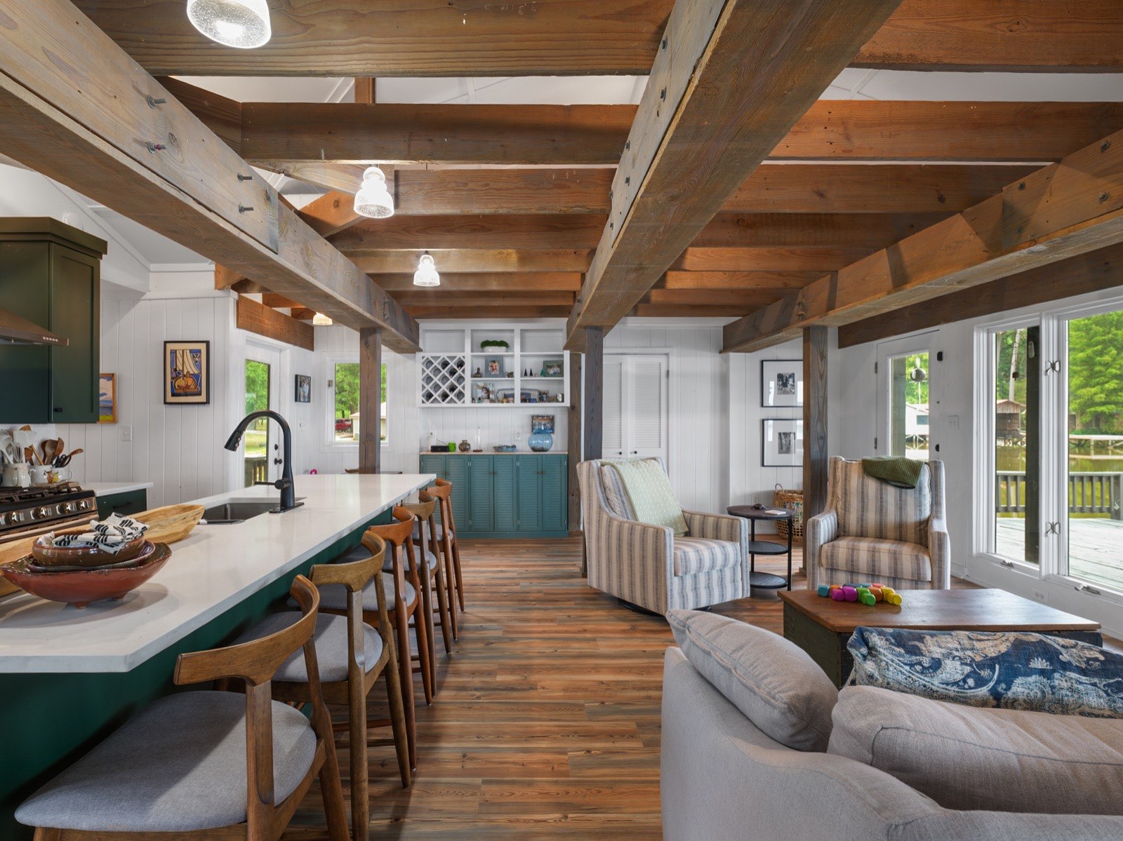 Open-concept kitchen and living space with timber beams and lake views